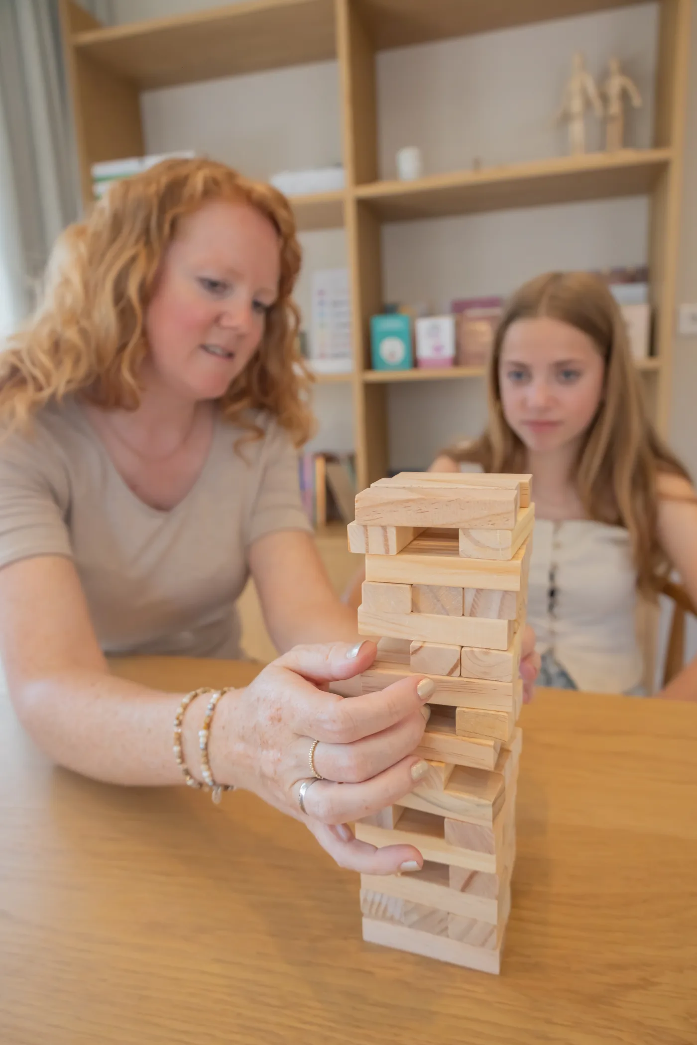 Jannie bouwt samen met een cliënt aan een houten toren tijdens een sessie